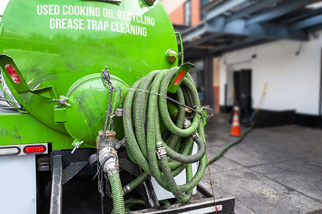 a technician pumping a grease trap in a commercial building in Cerritos